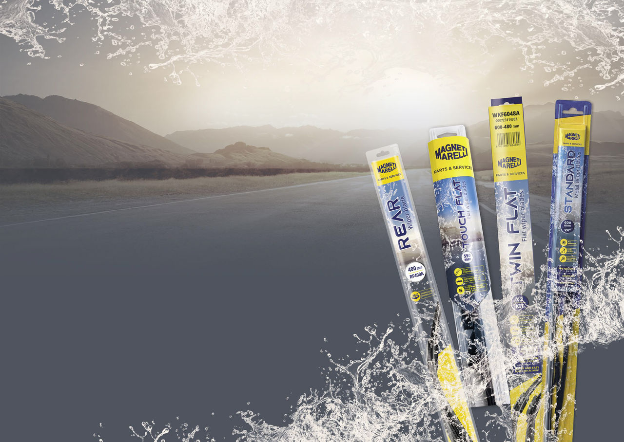 Quattro modelli di spazzole tergicristallo Magneti Marelli Parts & Services nel loro packaging, con una strada montana sullo sfondo e gocce d'acqua che simulano la visione del parabrezza pulito
